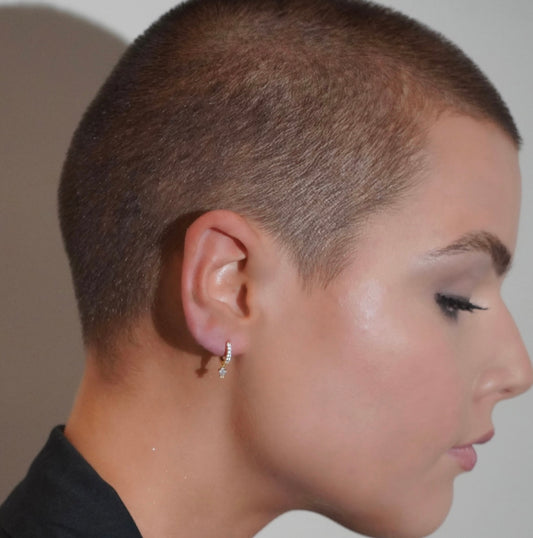Side profile of a person with a shaved head wearing Cubic Zirconia Huggie Hoop