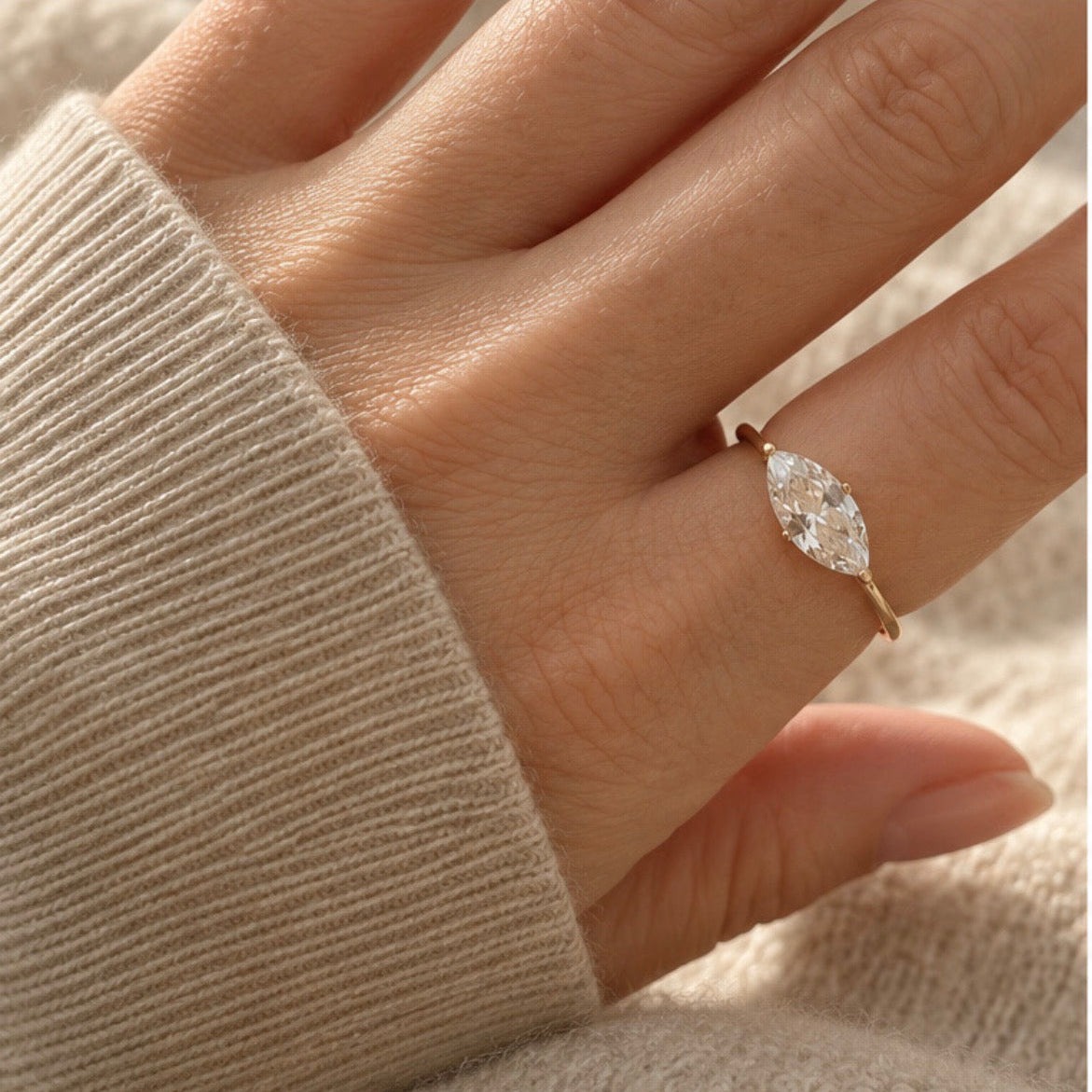 model wearing ring with a marquise cut stone on her index finger
