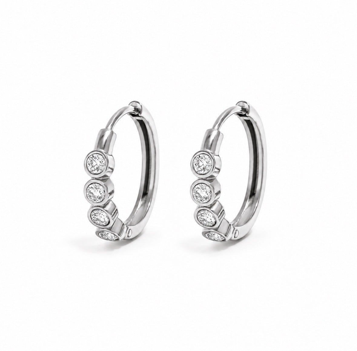 A pair of silver hoop earrings, each adorned with four round-cut clear gemstones in bezel settings, displayed on a clean white background.
