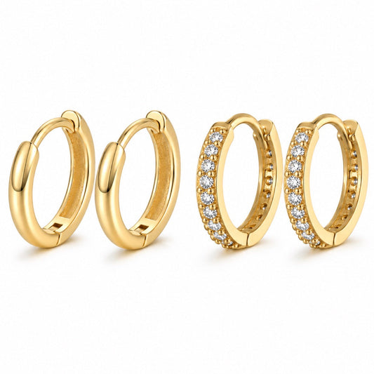 Four gold huggie hoop earrings on a white background, including two plain gold hoops and two gold hoops set with small clear stones.