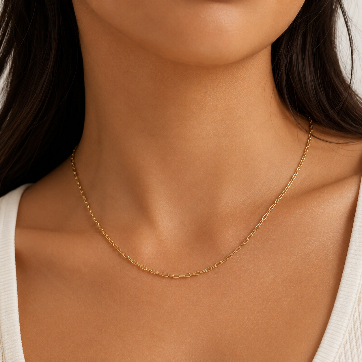 Gold stainless steel 2mm paperlink necklace on a person with a neutral background