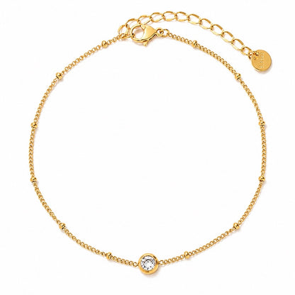 Gold anklet with a small round sparkly cubic zirconia. on a white background