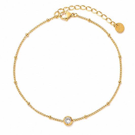 Gold anklet with a small round sparkly cubic zirconia. on a white background