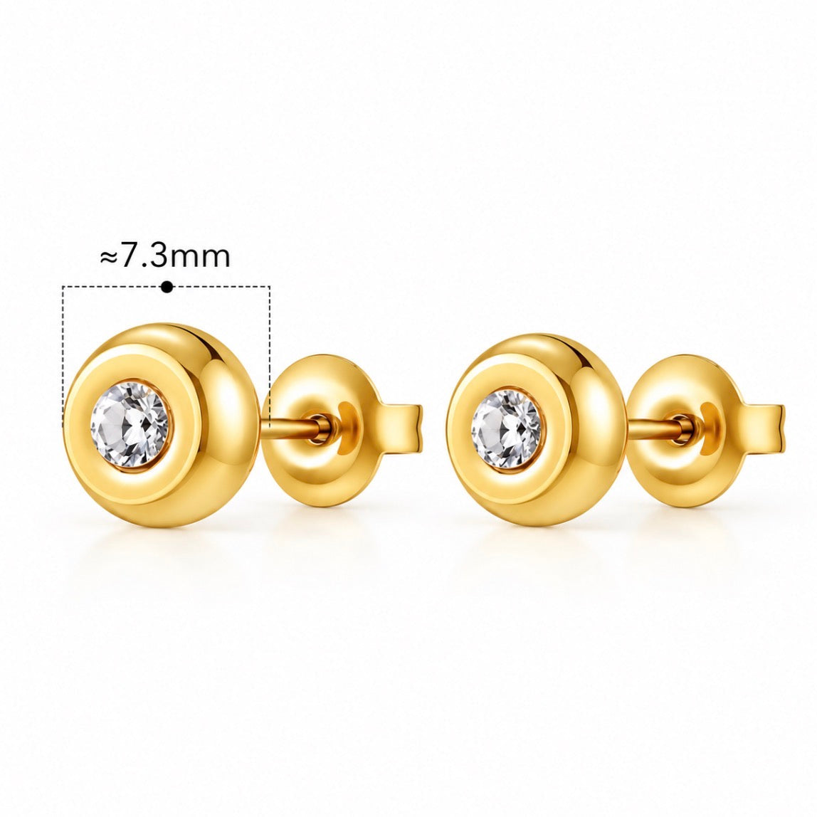 A pair of gold round stud earrings with a clear central gemstone, shown on a white background with a dimension label indicating approximately 7.3mm width.