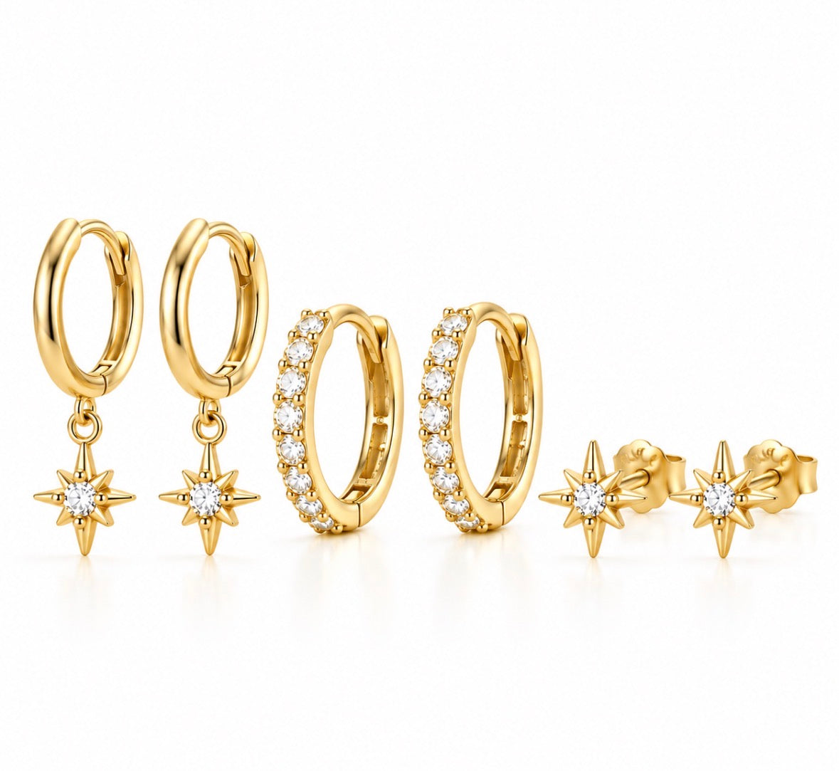 A set of gold huggie hoop earrings and stud earrings, featuring some hoops with clear pavé stones and others with dangling gold starburst charms set with round clear stones, displayed on a clean white background.