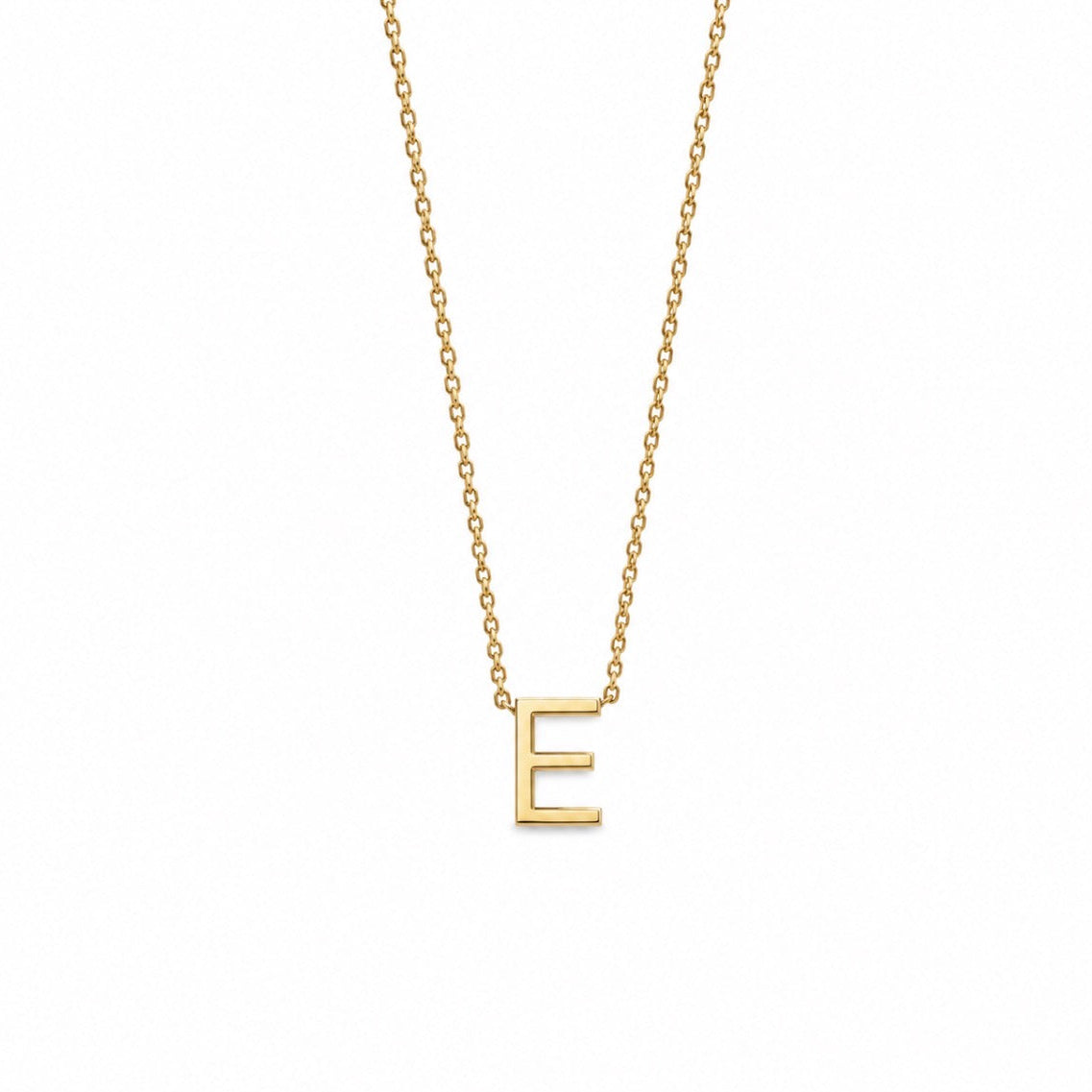 A delicate gold chain necklace featuring a polished gold initial pendant 'E', displayed against a solid white background.