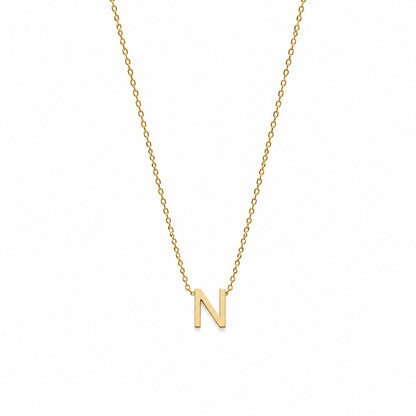 A delicate gold chain necklace featuring a small, polished gold initial pendant 'N' on a plain white background.