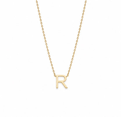 A delicate gold chain necklace featuring a polished gold initial pendant 'R', presented on a clean white background.