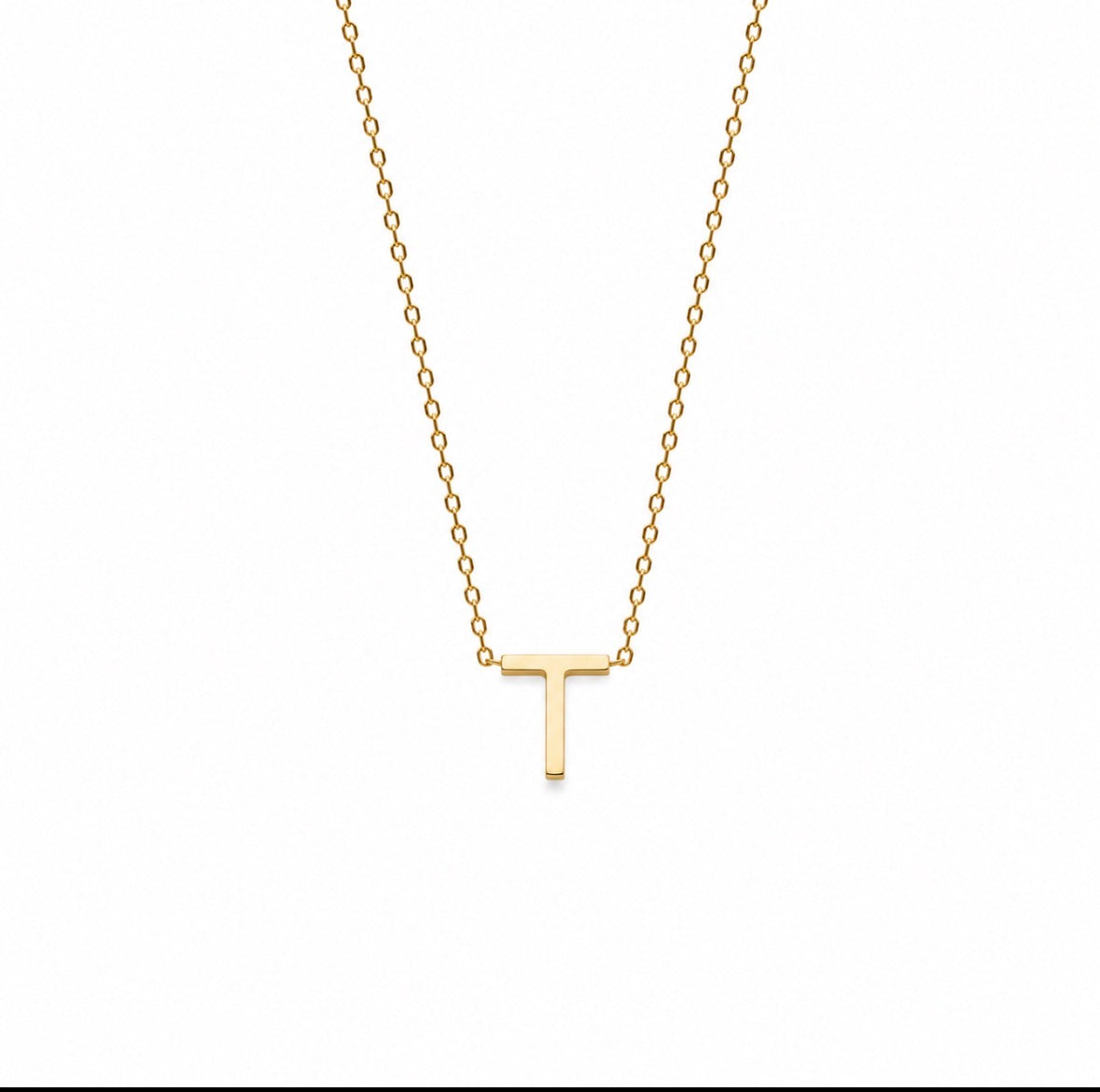 A delicate gold chain necklace featuring a small, polished capital letter 'T' pendant, shown against a plain white background.