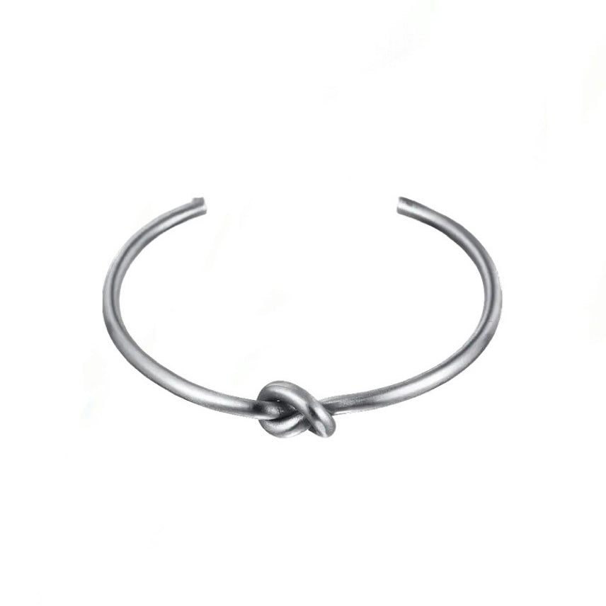 Silver knot detail cuff bangle on white background