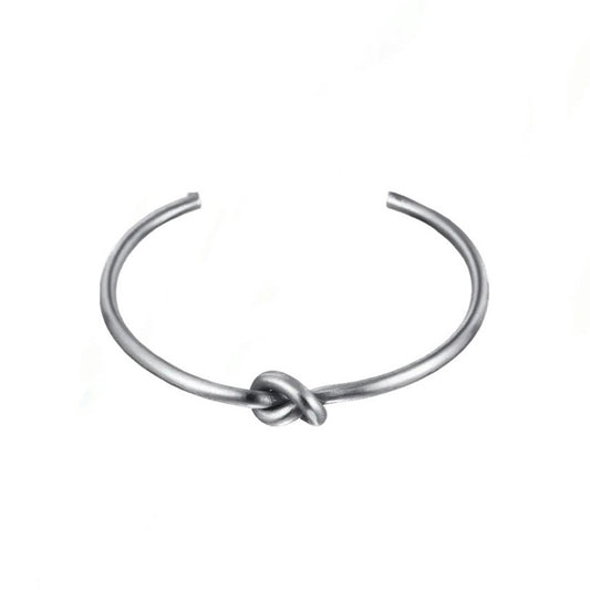 Silver knot detail cuff bangle on white background