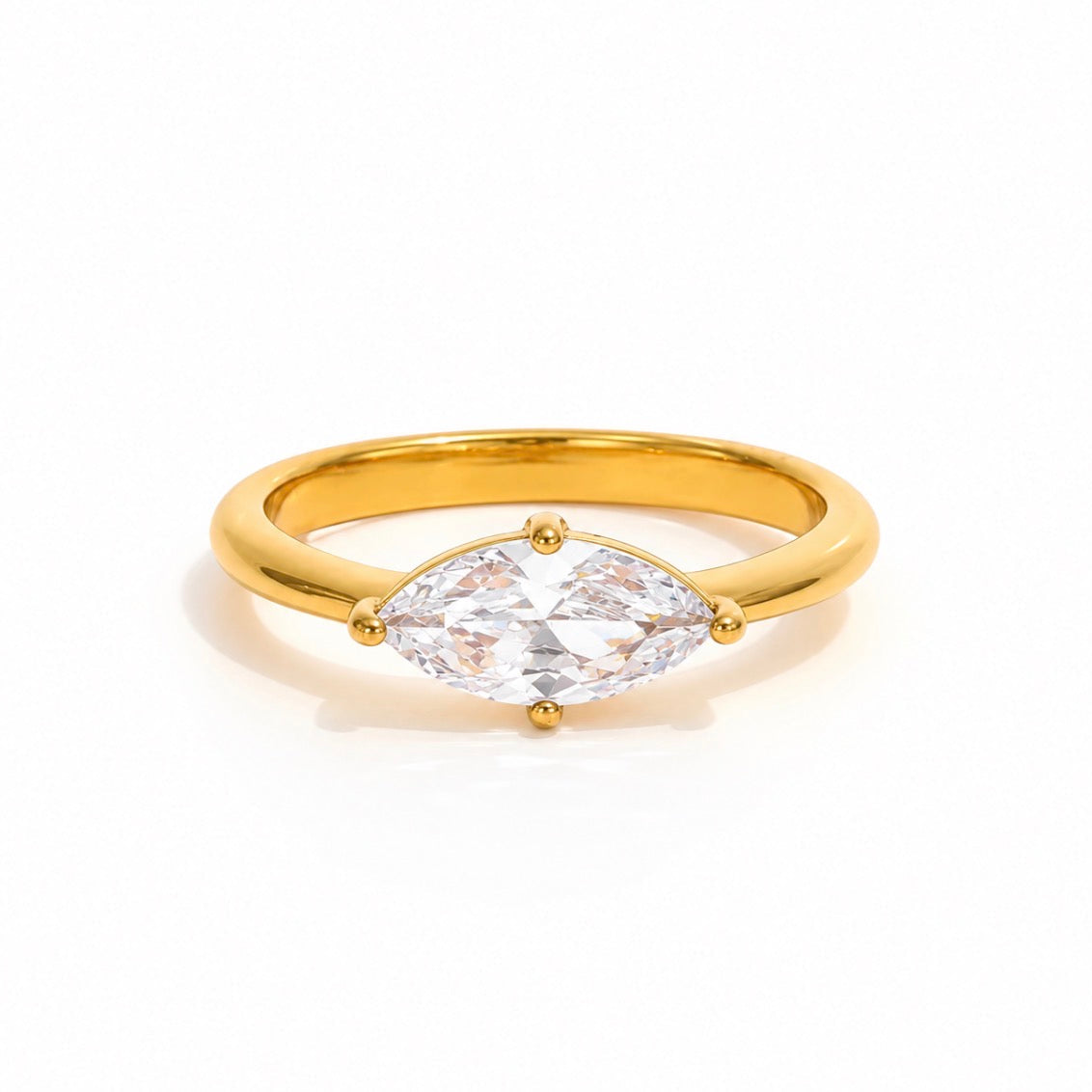A gold ring featuring a marquise-cut clear gemstone in a four-prong setting, shown on a clean white background.