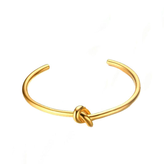 Gold knot open cuff bangle. with a twisted knot detail. 