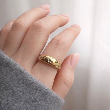 Gold ring on a finger with a blurred background