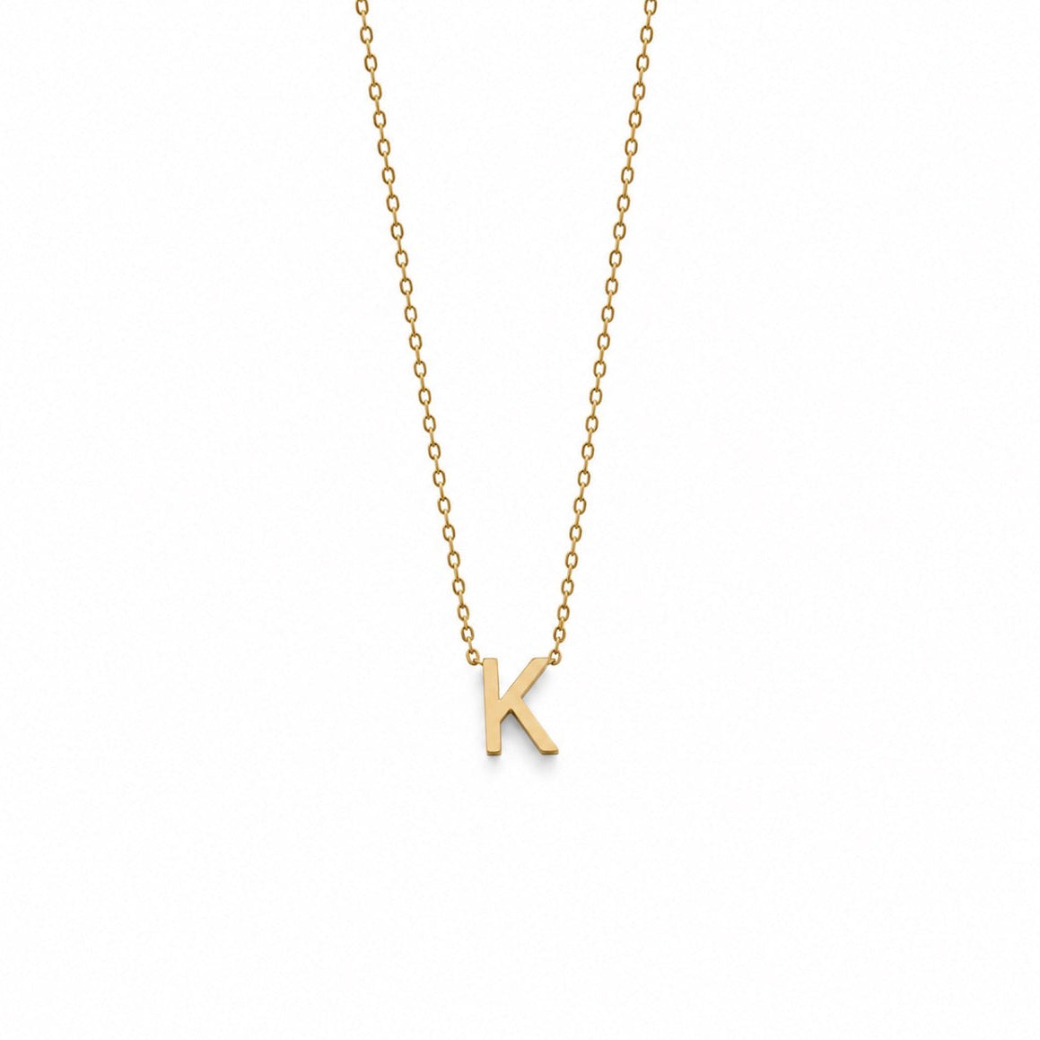 A delicate gold chain necklace featuring a small, polished gold initial pendant letter 'K', displayed against a solid white background.