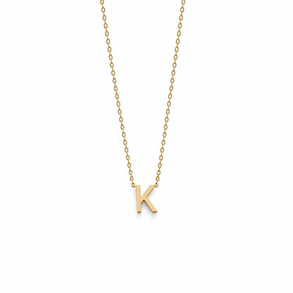 A delicate gold chain necklace featuring a small, polished gold initial pendant letter 'K', displayed against a solid white background.