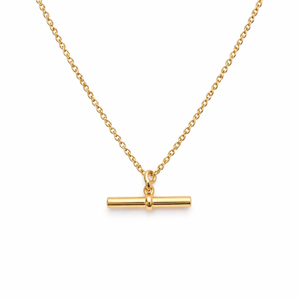 Gold necklace with a bar pendant on a white background