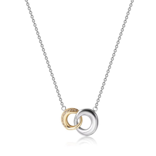 A delicate silver chain necklace featuring two interlocking circular pendant rings, one polished silver and the other gold with tiny engraved details, set against a clean white background.